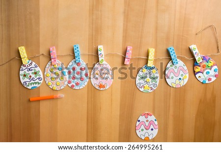 Easter activities and crafts project: colorful easter eggs decorated with pencils and markers and stickers, made into a banner