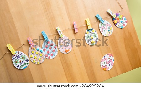 Easter activities and crafts project: colorful easter eggs decorated with pencils and markers and stickers, made into a banner