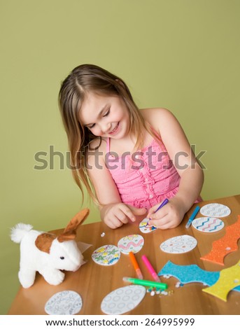 Child doing Easter activities and crafts with bunny stickers, Easter Egg shapes, pencils and markers.