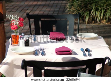 View of a small outdoor table at an outdoor restaurant set up for lunch