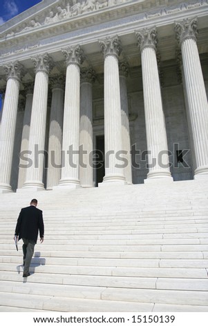 Professional, business man in black suit walking up the steps of the US Supreme Court