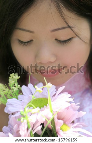 Portrait of a beautiful Asian female with flowers in a summer time, park setting