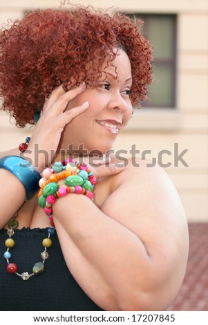 Portrait of a plus size female with short curly red hair and bright jewelry
