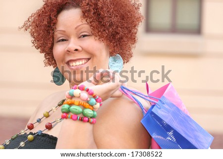 Plus size model, smiling about a purchase and looking into a shopping bag.