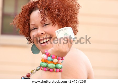 Plus size female model with red curly hair, colorful jewelry, holding money (five dollar bill)