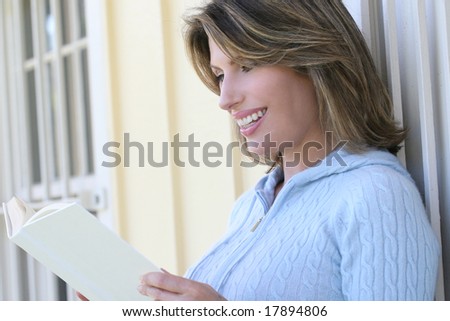 Beautiful woman reading a book outdoors, in a park setting