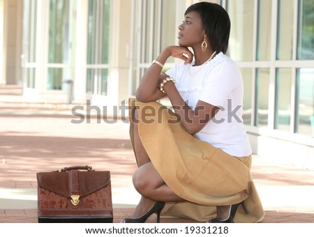 Beautiful African American Business, Corporate woman outdoors in front of a corporate building, thinking or waiting