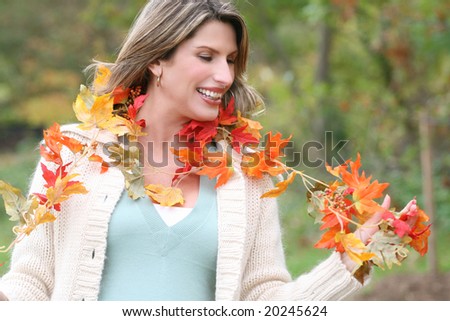 Gorgeous caucasian woman with fall leaves enjoying a great day in a park, seasonal theme