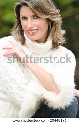 Winter or Christmas Holiday Theme: Gorgeous woman in a white sweater, portrait. Suitable for a variety of seasonal, advertising themes