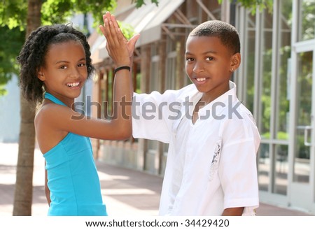African-American Teenager Friends doing a high five, city street