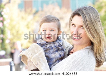 Family: mother and baby son outdoors, city street setting, fall