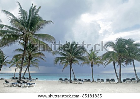 Tropical storm on an empty white sand beach, ocean and palm trees in Mexico, Riviera Maya