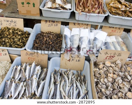 bins of dried seafood and mushrooms at the seafood market in China town, priced and labeled in Chinese.