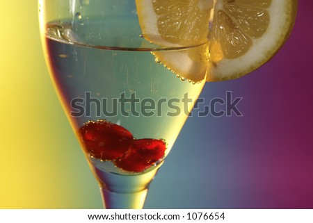 Glass of champagne with a cherry and a lemon