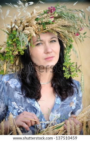 Portrait of a woman with a flower crown in the wheat field