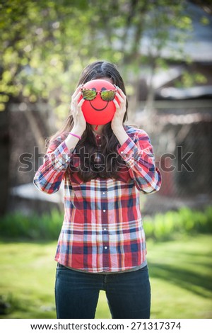 Young girl with a balloon face sunglasses on vertical