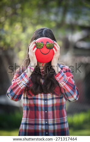 Close-up of a young girl with a balloon face with sunglasses on vertical