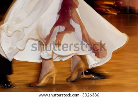 Woman\'s feet between man\'s feet dancing on parquet floor