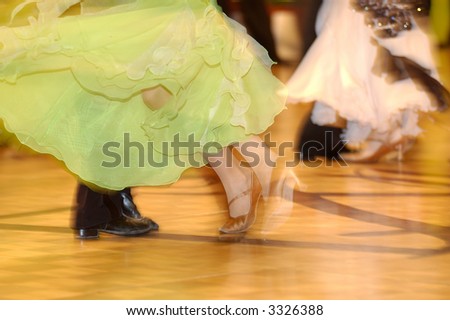 Woman\'s legs in green semitransparent dress against man\'s legs in black suit dancing