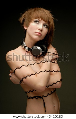 stock photo Naked girl tied up with headphone wire having dreaming look