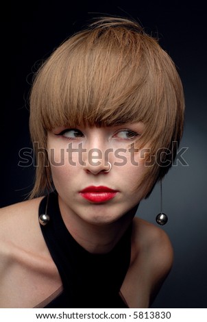 Close-up portrait of girl both shoulders seen wind blown hair looking sideways