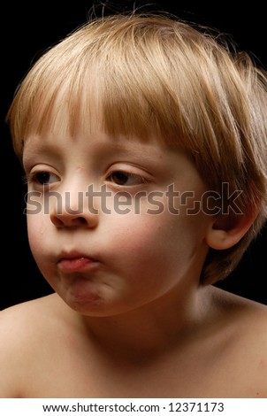 Close-up of little boy looking sideways biting lips