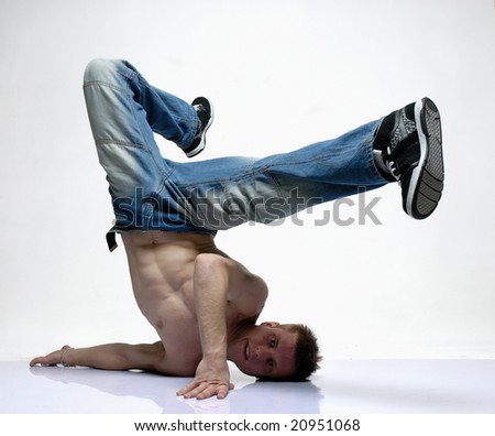 B-boy dancer laying on the floor with his shoulder lifting his legs to the right
