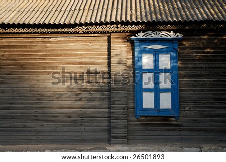 One window with closed blue and white window shutters of a wooden house horizontal