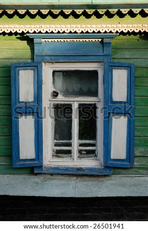 one window with open blue and white wooden shutters on green wall