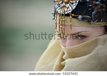 Close-up of a tribal woman hiding her face looking sideways cropped