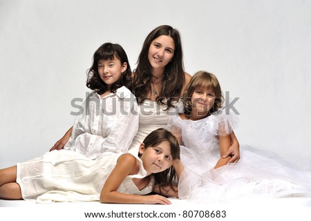 Four sisters in white posing against the white background