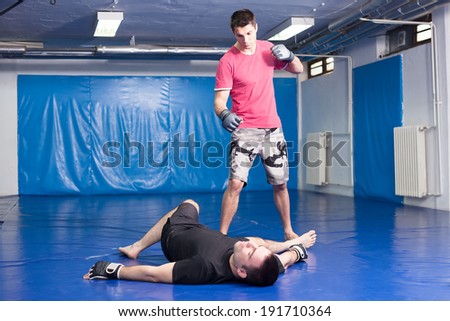 fighter lying on blue mats during the box training