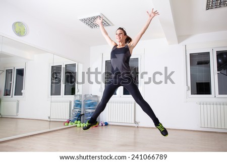 woman jumps in empty gym