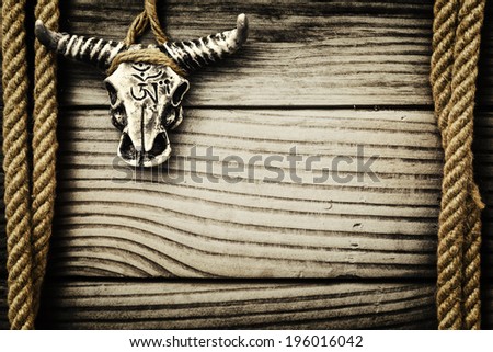 Buffalo skull on wooden background with frame made of ropes