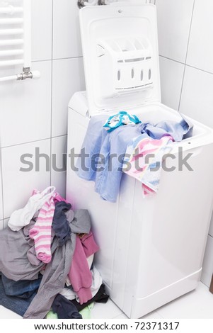 Pile of dirty laundry next to washing machine