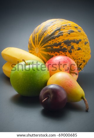 Fruits. Fresh, ripe colorful fruits - plum, pear, apples, bananas and melon arranged on dark background