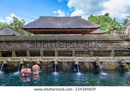 persons pray and bath themselves in the sacred waters of the fountains, in Tirta Empul, Bali, Indonesia