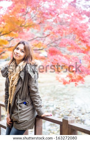 Beautiful asian woman standing in autumn season on nami island, Korea.