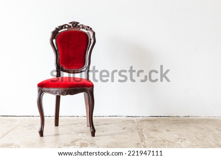 Red vintage armchair on white wall.