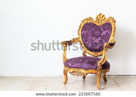 Violet vintage armchair on white wall.