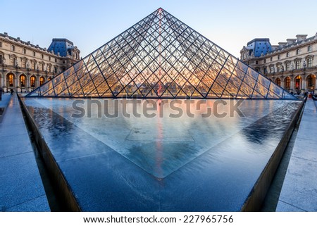 PARIS, FRANCE - JULY 19: The Louvre Pyramid at dusk during the Michelangelo Pistoletto Exhibition on July 19, 2014 in Paris. The Pyramid is the main entrance to the Louvre Museum.