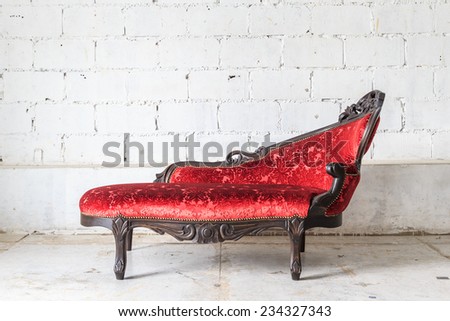 Red vintage sofa on white wall.