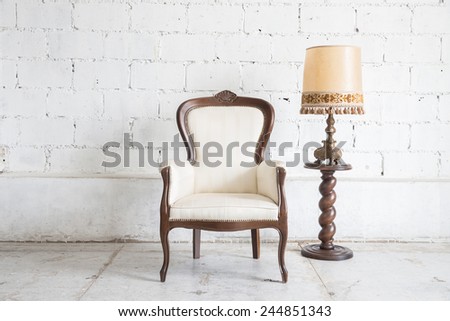 White vintage armchair on white wall.