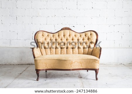Yellow sofa armchair on white wall.