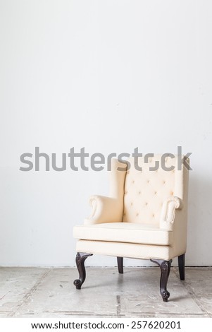 White sofa armchair on white wall.