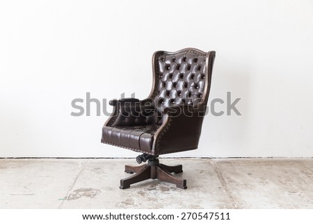 Black vintage armchair on white wall.