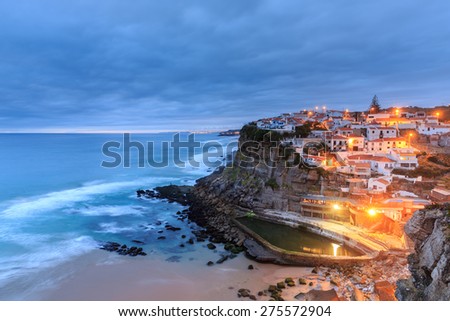 Azenhas do Mar village at dusk with stormy sea and dark clouds, Sintra Portugal