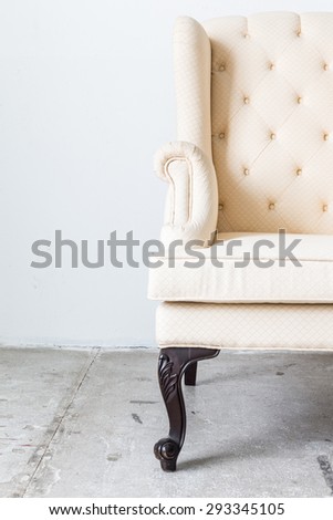 White sofa armchair on white wall.