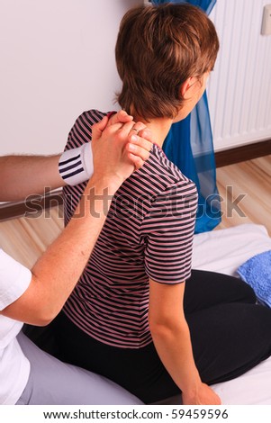 Kneeling young woman gets back massage at yumeiho session
