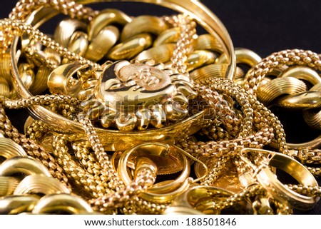 Closeup of yellow gold jewelery on a black background